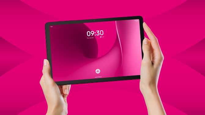 T Tablet 2 trzymany w rękach na magentowym tle