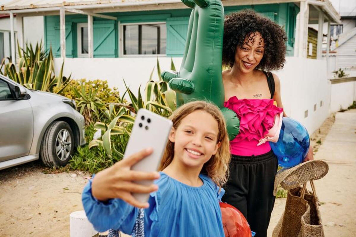 Dziewczynka robi selfie sobie i dorosłej kobiecie podczas drogi na plażę