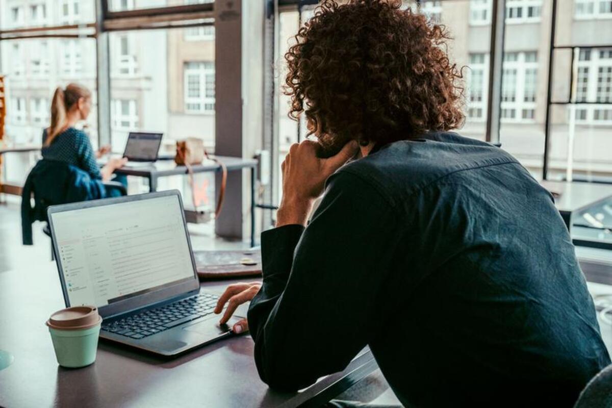 Mężczyzna pracuje na laptopie z internetem 5G, korzystając z przestrzeni coworkingowej
